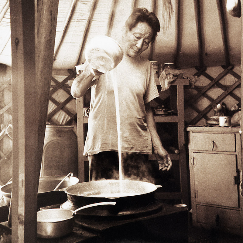 Photo of a woman cooking airag in a yurt in Mongolia